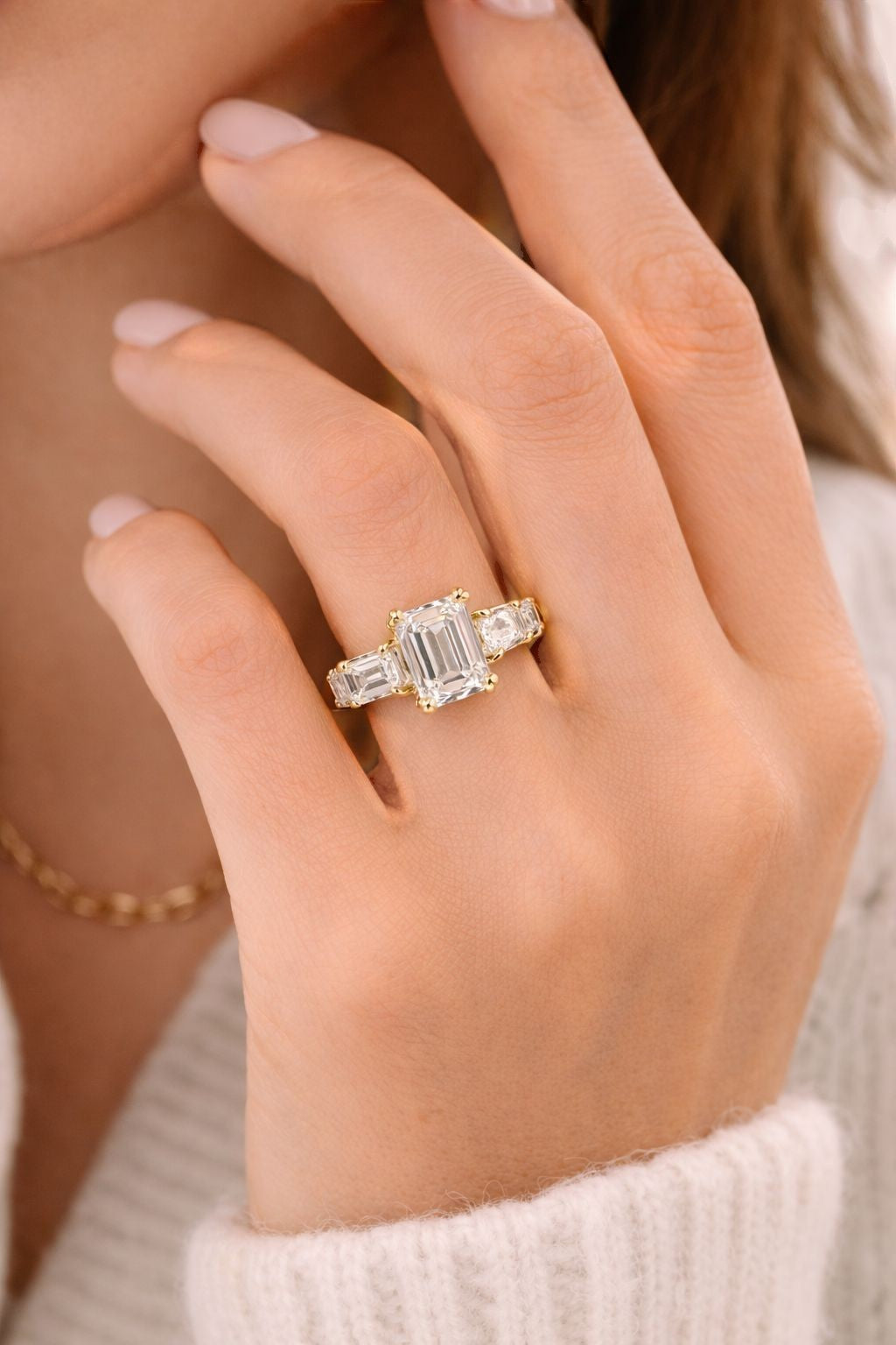 Vikchi Isola Vira Aura Ring: 3.6ctw emerald-cut diamond center stone with tapered baguette side stones in 14K gold.